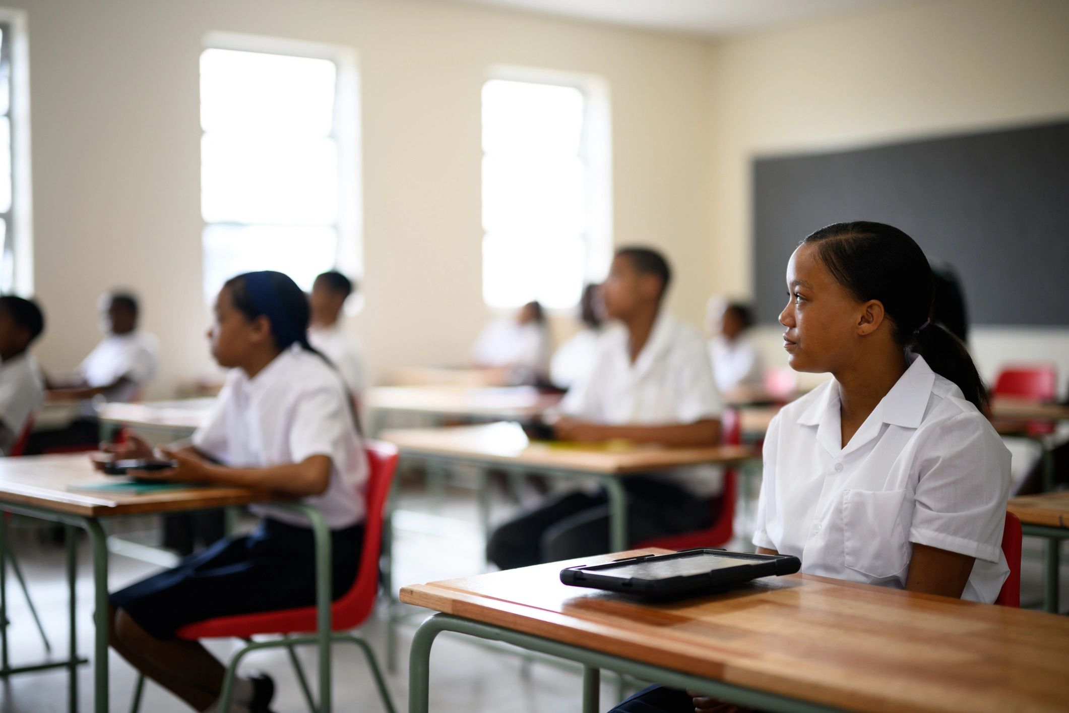 Students learning with digital tablets in a classroom