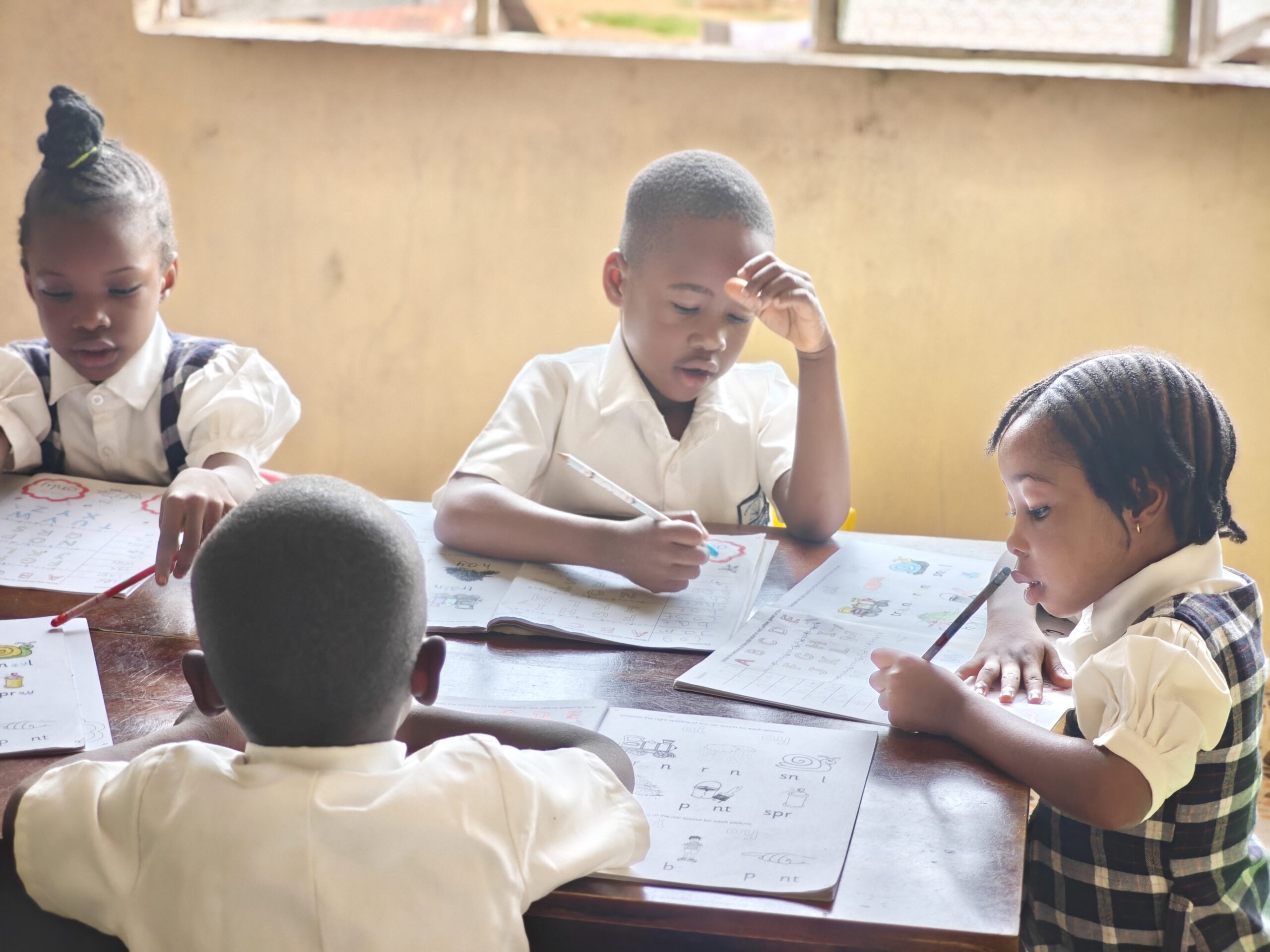 Ark of Hope early-years pupils writing and drawing together at a classroom table